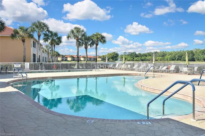 Community pool with a patio and fence