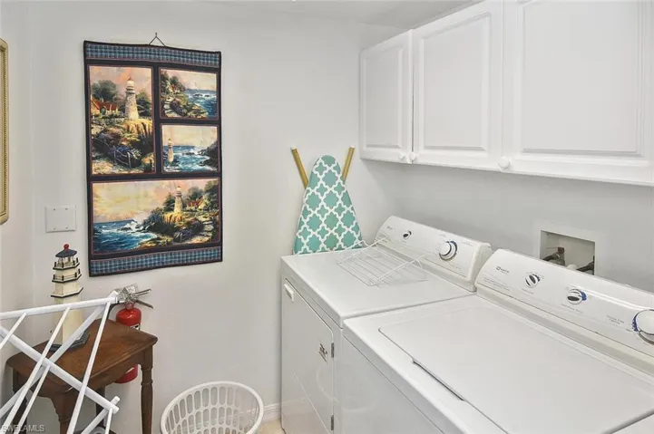 Laundry area with washing machine and dryer, baseboards, and cabinet space