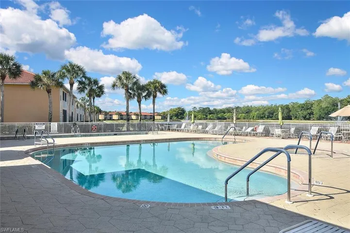 Community pool featuring fence and a patio