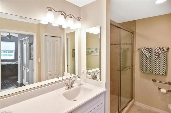 Full bathroom featuring a shower stall, ensuite bath, toilet, and vanity