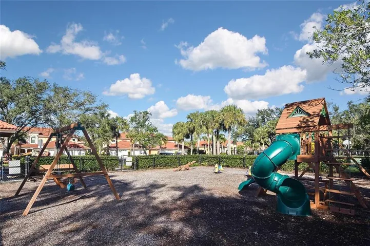 Community jungle gym featuring fence and a residential view