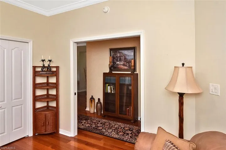 Hallway featuring ornamental molding and dark wood-style flooring