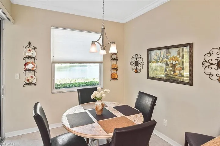 Dining area featuring light tile patterned flooring, crown molding, and baseboards