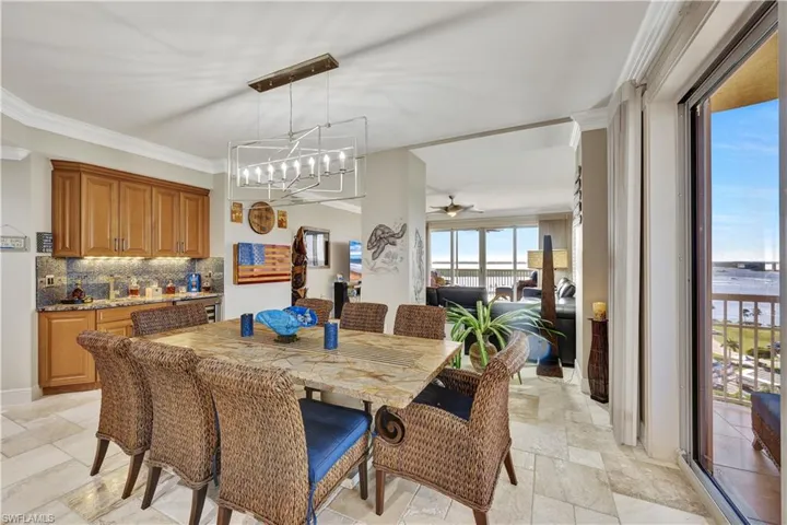 Dining space with ornamental molding and ceiling fan with notable chandelier