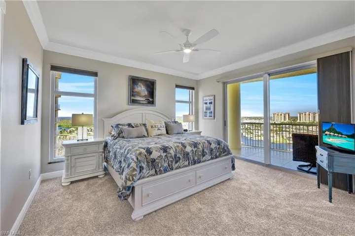 Bedroom featuring ceiling fan, multiple windows, and light colored carpet