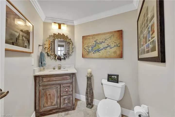 Bathroom featuring vanity, ornamental molding, and toilet