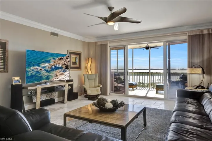 Living room featuring crown molding and ceiling fan