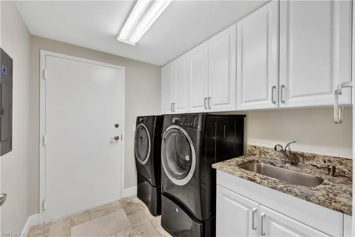 Laundry room featuring cabinets, independent washer and dryer, and sink