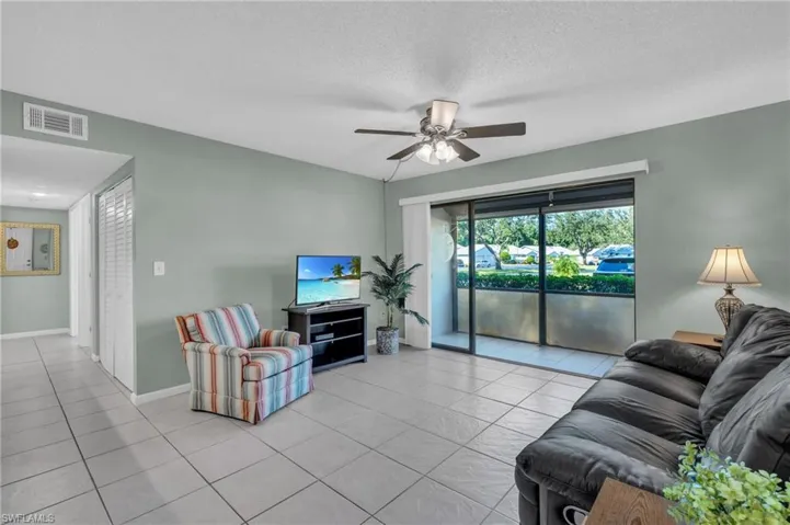 Living room is bright and airy with sliding glass door to balcony