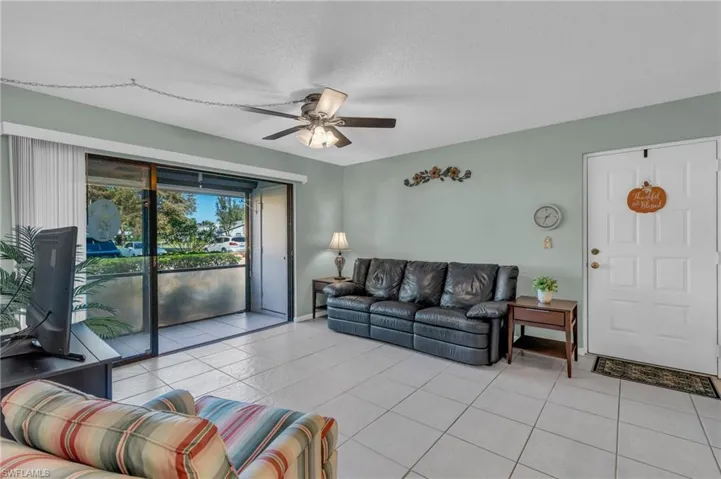 Living room is bright and airy with sliding glass door to balcony