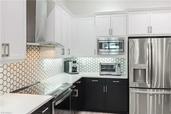 Fully renovated kitchen with stainless steel appliances, quartz countertops and custom backsplash.