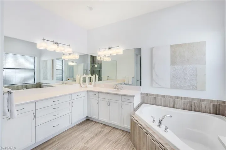Primary bathroom with glass enclosed shower, dual sinks and tub.
