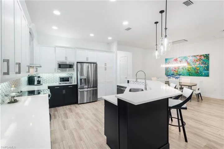 Fully renovated kitchen with stainless steel appliances, quartz countertops and custom backsplash.