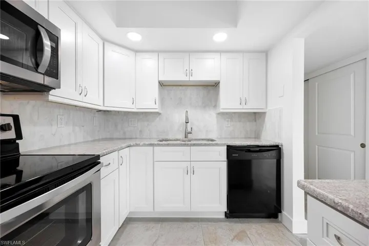 Kitchen featuring white cabinetry, sink, and appliances with stainless steel finishes