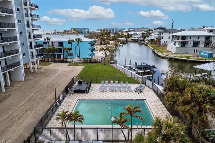 View of swimming pool with a patio area, a water view, and a yard