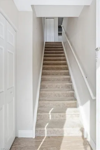 Staircase with baseboards and wood finished floors