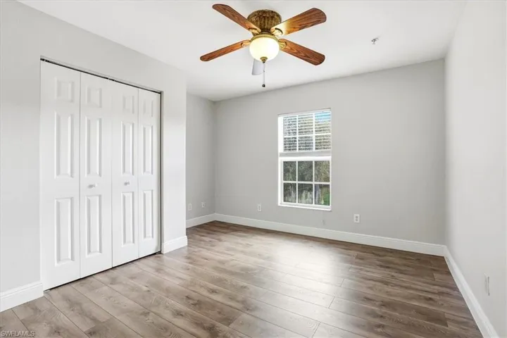 Unfurnished bedroom featuring light wood-style floors, ceiling fan, and a closet