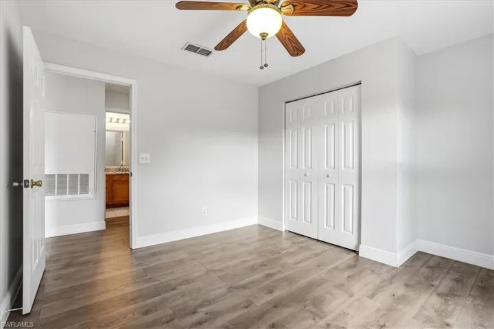 Unfurnished bedroom featuring light wood finished floors, a closet, and a ceiling fan