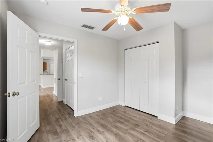 Unfurnished bedroom with light wood-style flooring, a closet, and a ceiling fan