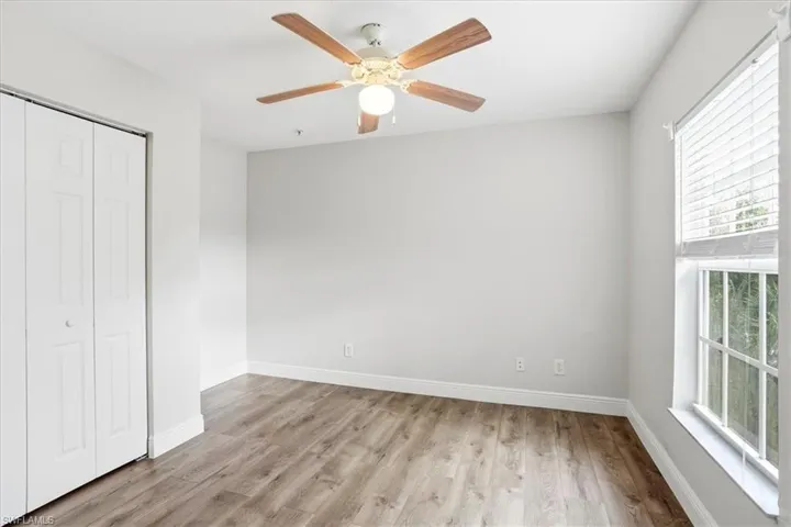 Unfurnished bedroom with light wood finished floors, a closet, and a ceiling fan