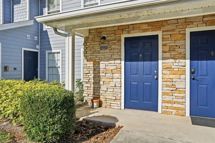 Doorway to property with a porch and stone siding