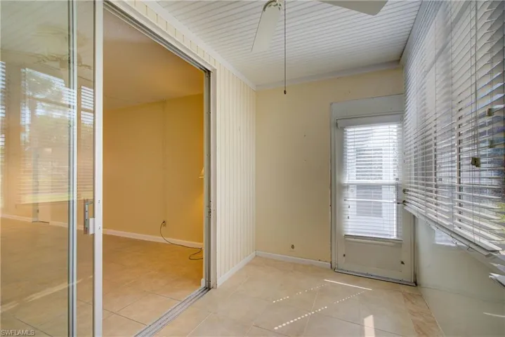 Well lit sun room overlooking the courtyard towards community center.