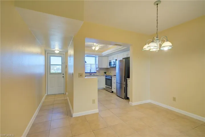 Dining Room area with suspended lighting and a raised ceiling.