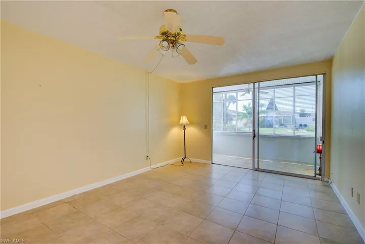 Living area with a ceiling fan and light tile patterned floors