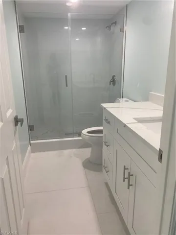 Bathroom featuring vanity, a stall shower, and light tile patterned floors