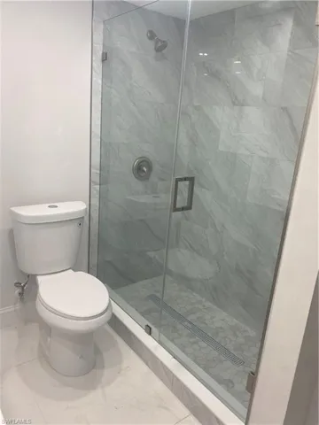 Bathroom featuring a stall shower and marble finish floors