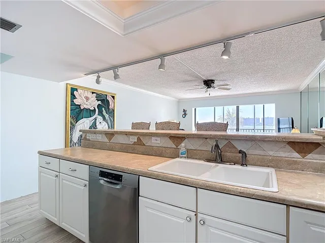 Kitchen featuring rail lighting, dishwasher, white cabinetry, a ceiling fan, and light wood-type flooring