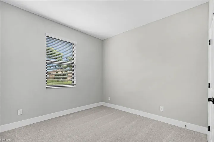 Carpeted empty room with baseboards