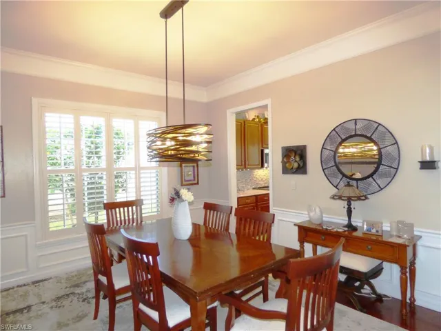 Dining room featuring crown molding and wood flooring.