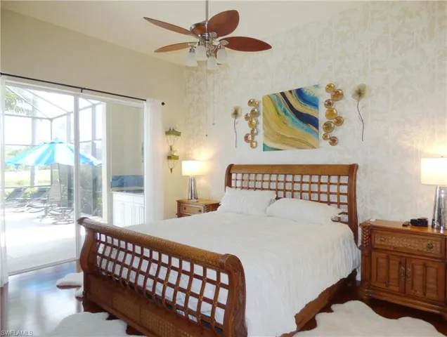 Master Bedroom featuring wood flooring, ceiling fan, and access to pool area.