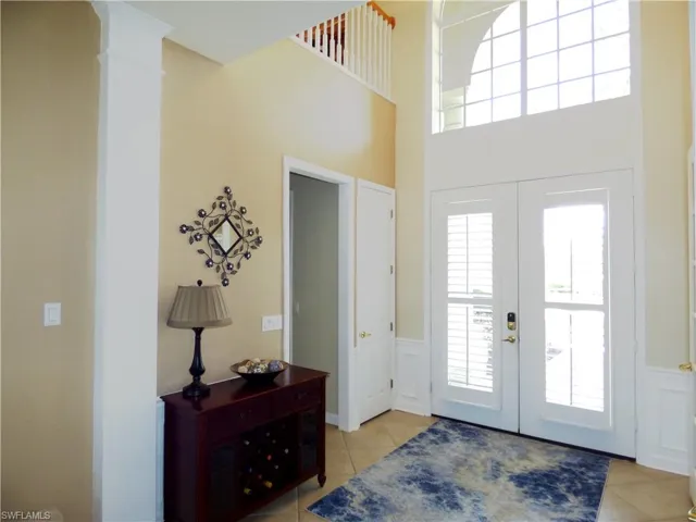 Foyer with french doors and a towering ceiling.