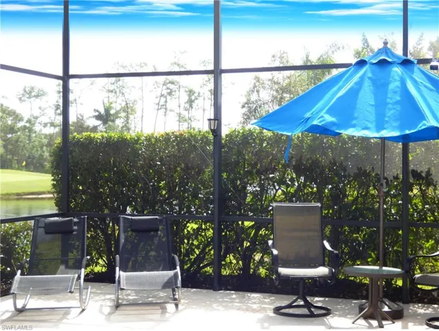 View of lanai relaxing area with golf course green in background.
