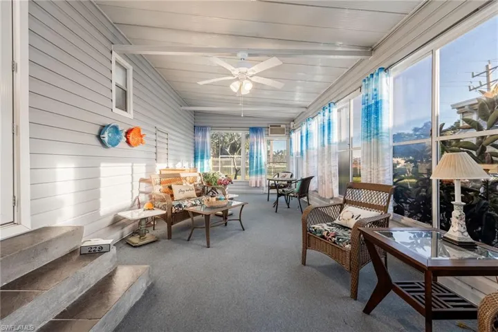 Sunroom / solarium featuring a ceiling fan, vaulted ceiling, an outdoor living space, and outdoor dining space