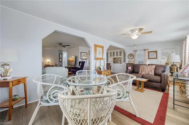 Dining area featuring ceiling fan, wood finished floors, and arched walkways
