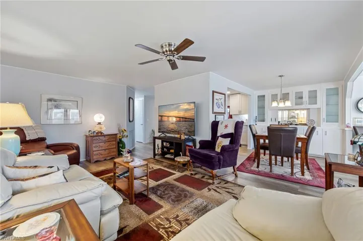 Living area with wood finished floors, a chandelier, and ceiling fan