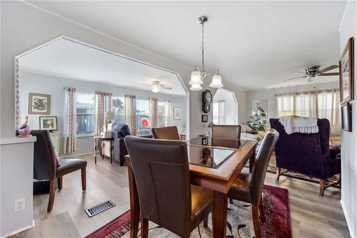 Dining space featuring a ceiling fan, light wood-style floors, and a chandelier
