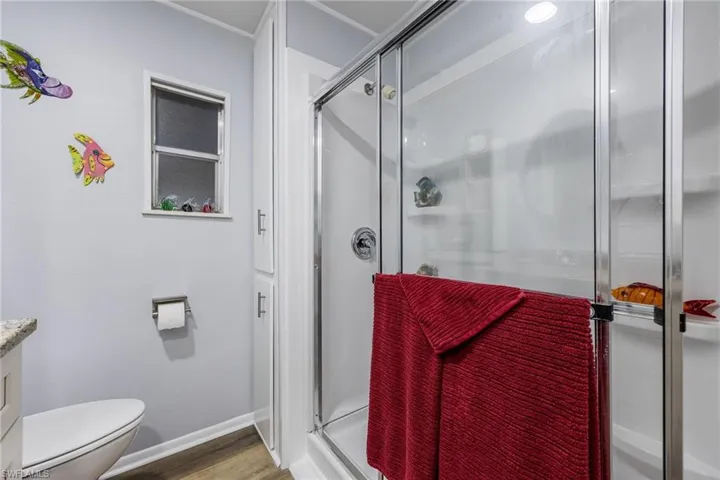 Bathroom featuring a stall shower, wood finished floors, and vanity