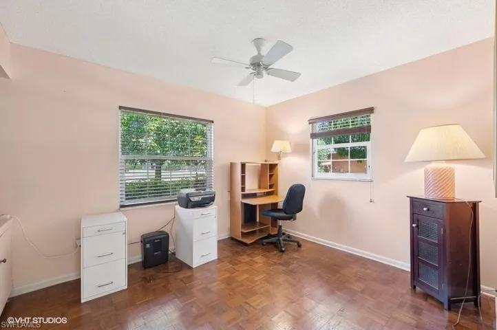 Home office with baseboards, ceiling fan, and a textured ceiling