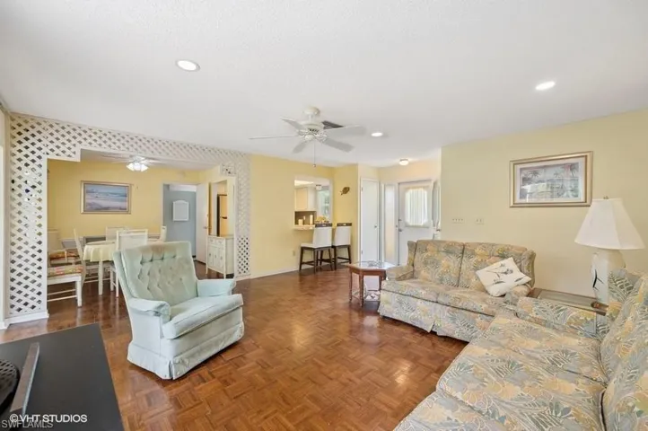 Living area featuring baseboards, ceiling fan, recessed lighting, and a textured ceiling