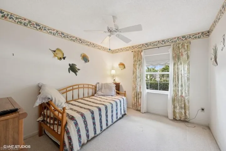 Carpeted bedroom with a ceiling fan, baseboards, and a textured ceiling
