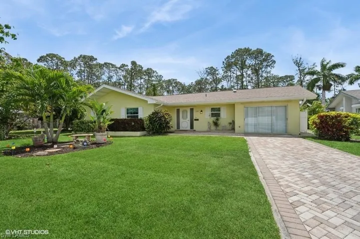 Ranch-style house featuring a front lawn, decorative driveway, stucco siding.
