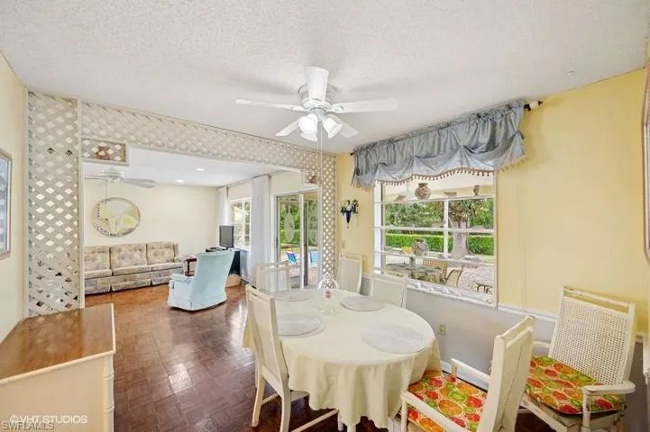 Dining space featuring a textured ceiling, baseboards, and a ceiling fan