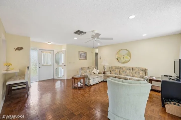 Living area featuring recessed lighting, a textured ceiling, ceiling fan, and visible vents