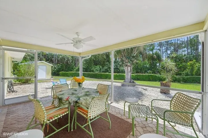 View of patio / terrace with an outbuilding, a storage unit, outdoor dining space, and ceiling fan