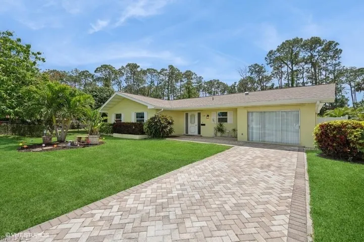 View of front facade featuring a front yard and stucco siding