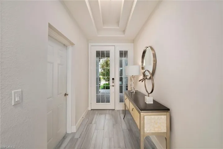 Doorway featuring a tray ceiling
